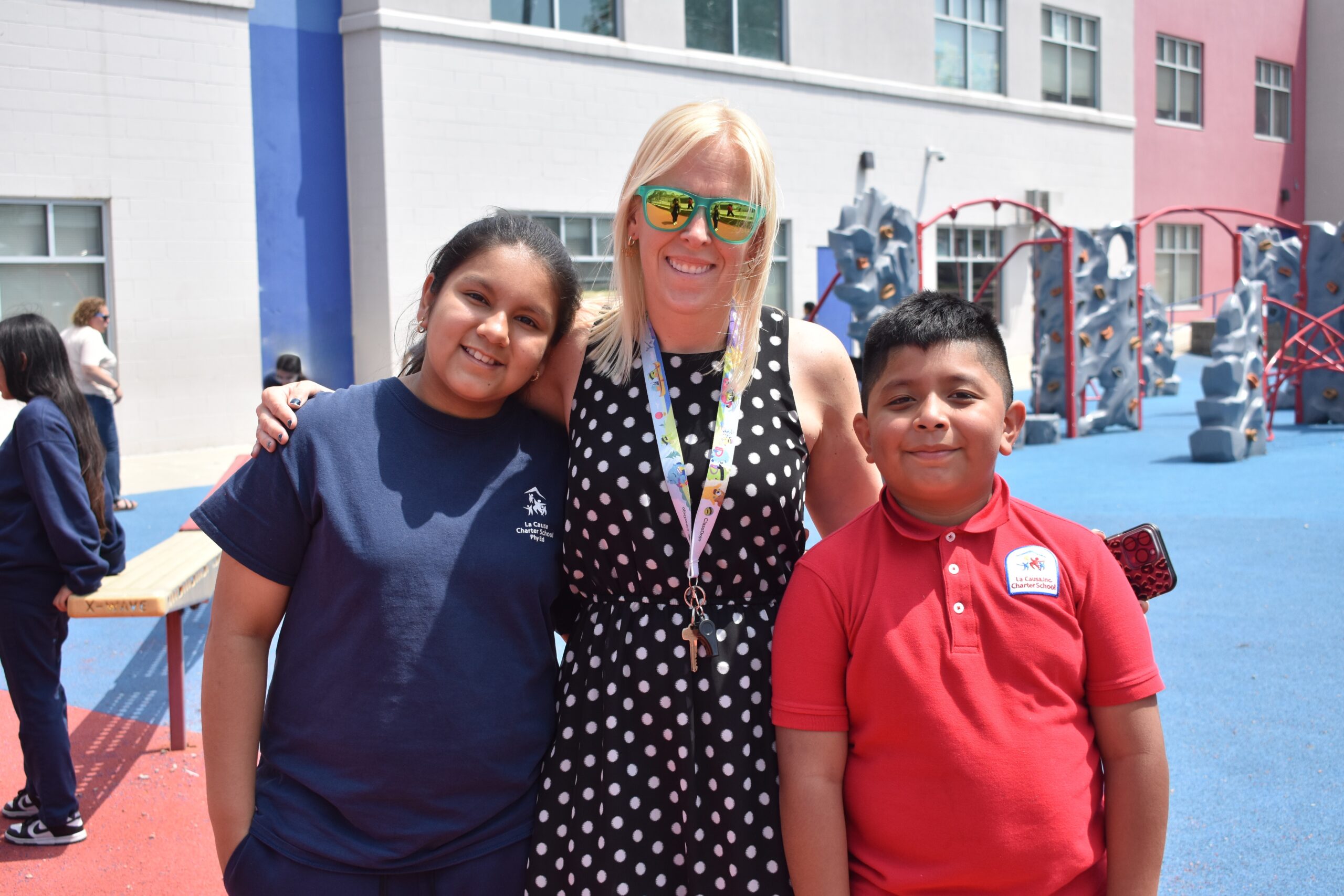 Dual Language, Two Way Immersion Niño sonriendo a la cámara mientras está sentado en el aula activa junto a otros estudiantes